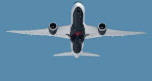 Jet airliner seen from below against blue sky