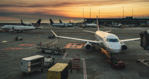 Passenger plane at airport gate during sunset