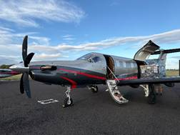 Black private turboprop plane with open door