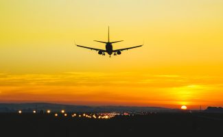 Airplane landing on the runway during sunset and dusk
